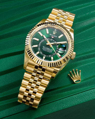 Rolex Sky-Dweller 42mm in 18k yellow gold with bright green dial and Jubilee bracelet, reference 336938, displayed on green box.
